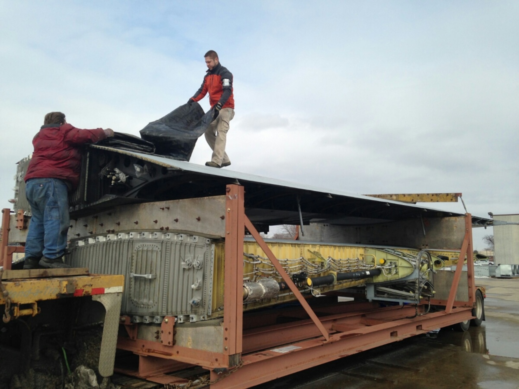 Matt Russell, 934th Logistics Readiness Squadron, assists in preparing C-130 wings for transport to Robins AFB, Ga. March 17. The outer wings from "Frankenherc" will find new life on a Coast Guard C-130. (Air Force Photo/Mike Dressen)