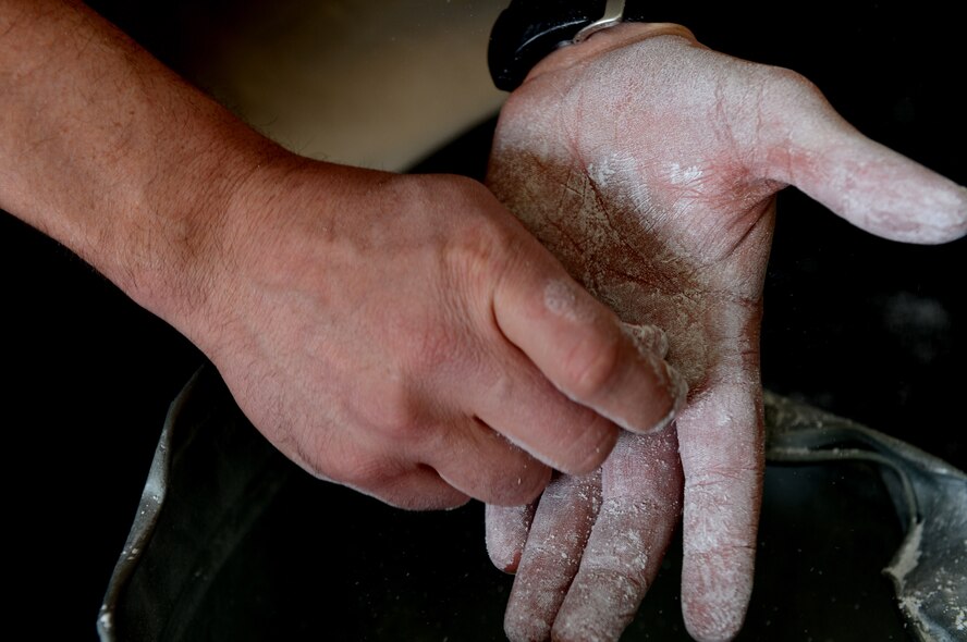 David Esra, 52nd Force Support Squadron combat fitness programs manager from Jackson, Tenn., applies chalk to his hands at Spangdahlem Air Base, Germany, March 14, 2014. Chalk helps absorb sweat and allows for a better grip on equipment such as a barbell. (U.S. Air Force photo by Airman 1st Class Kyle Gese/Released)