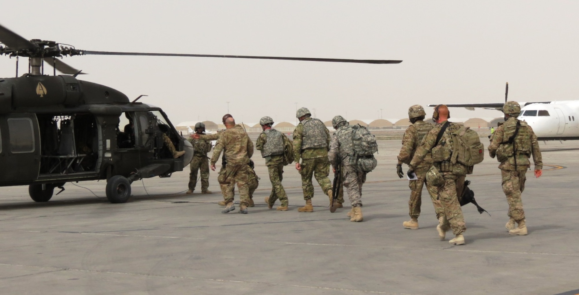 A group of wounded warriors walk out to load onto a helicopter at Kandahar Airfield, Afghanistan, after completing the fifth edition of Operation Proper Exit, March 13, 2014.  This was the 15th overall operation organized by Rick Kell, co-founder of Troops First Foundation. The program is intended to gain a sense of commonality, pride and closure for soldiers severely injured in the line of duty. (U.S. Air Force photo by Senior Airman Alexandria Bandin/Released)