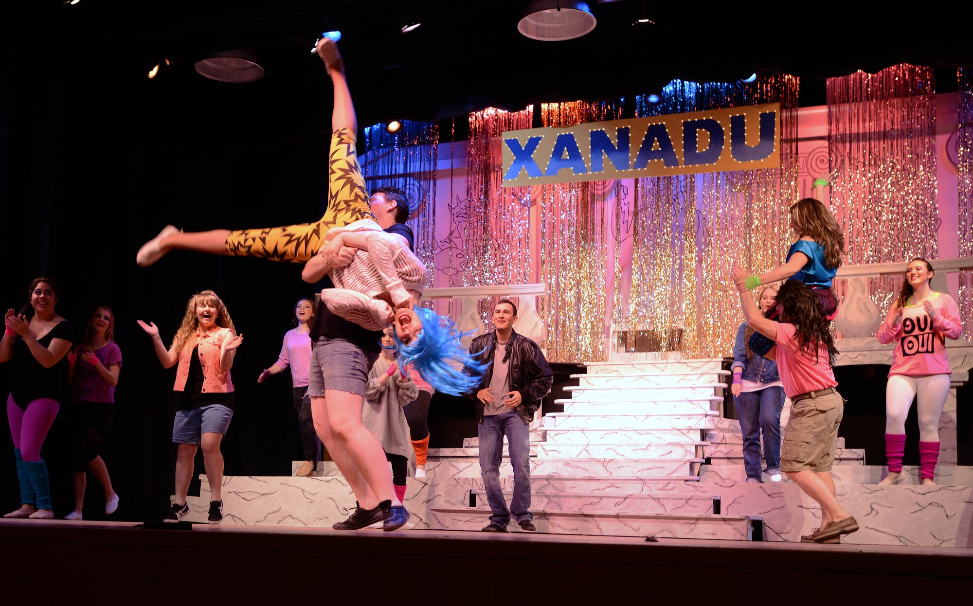 Members of the cast dance for their last act during the Aviano Community Theater dinner theater performance of “Xanadu,” March 15, 2014, at Aviano Air Base, Italy. “Xanadu” is an ‘80s love story between an uninspired artist and a Greek muse who helps him fulfill a lifelong dream of opening a roller disco. (U.S. Air Force photo/Airman 1st Class Deana Heitzman)        