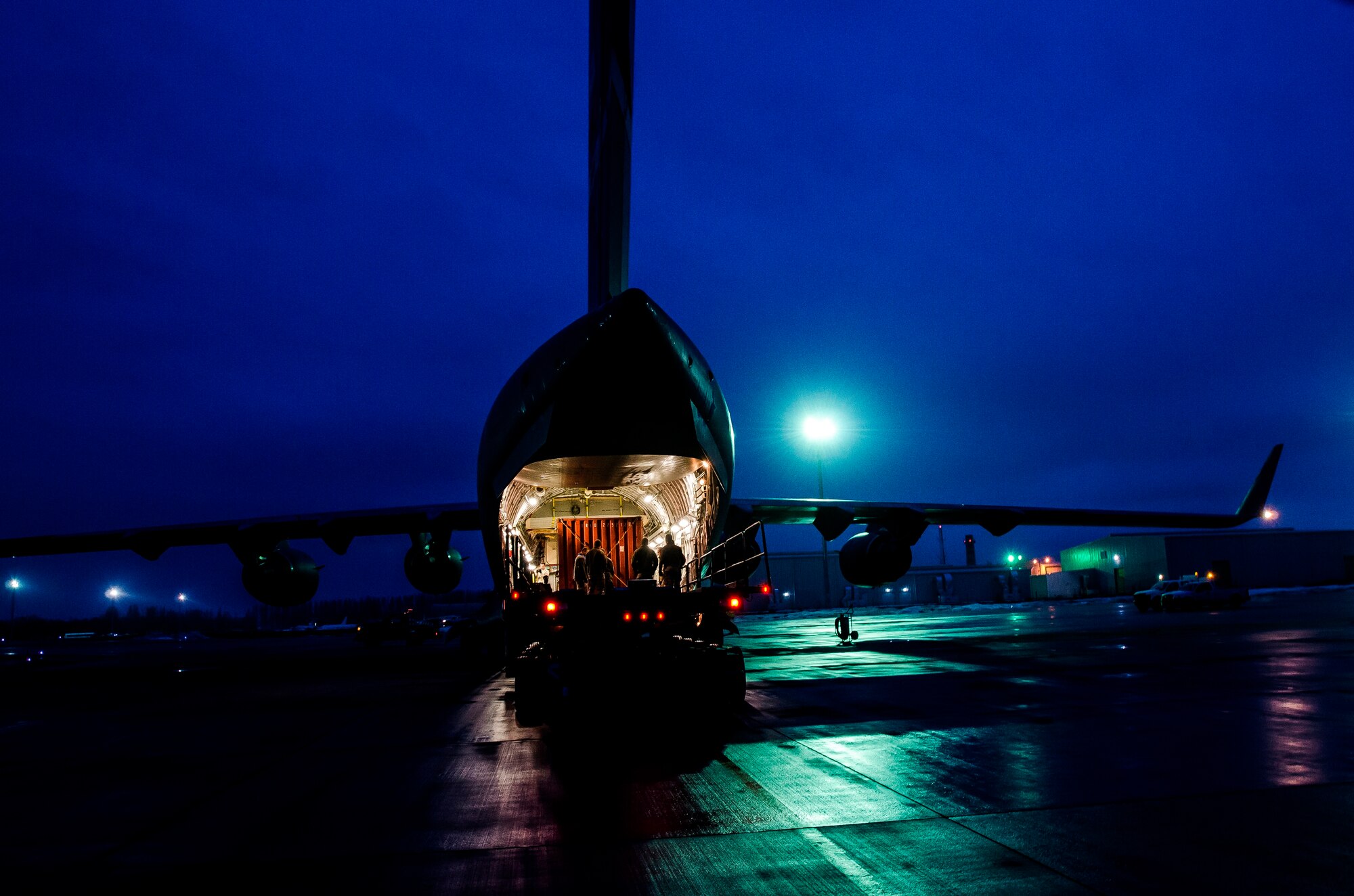 Loadmasters, ramp service specialists and other Airmen load cargo onto a C-17 Globemaster III at Transit Center at Manas, March 14, 2014. C-17s contribute to cargo and equipment movement from the Transit Center. The transfer of equipment is in preparation for the Transit Center closure, scheduled for July 10, 2014. (U.S. Air Force photo/Senior Airman Ross Alexander Whitley)