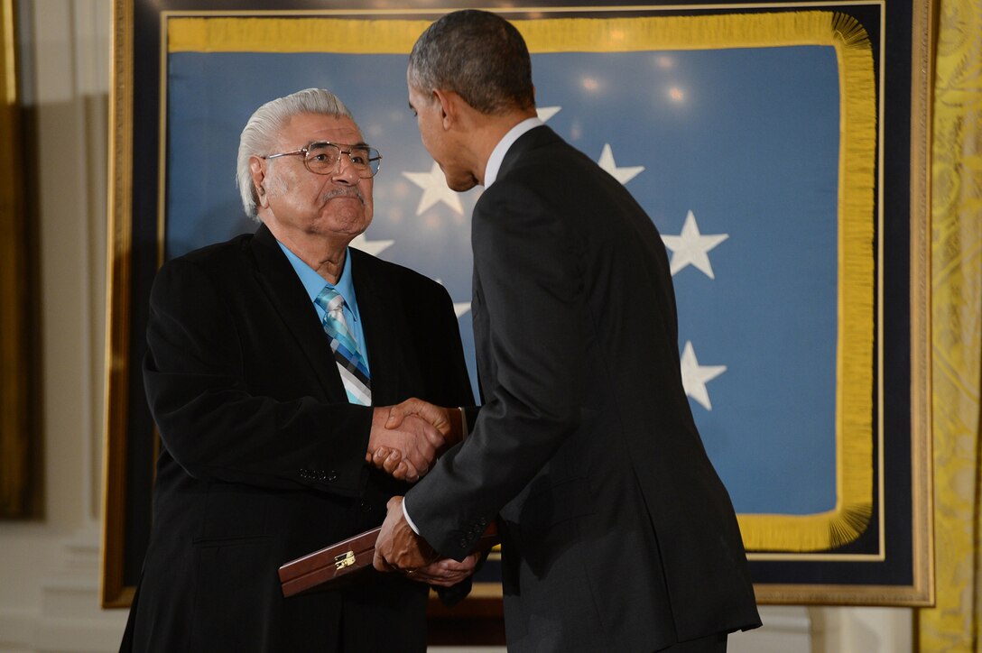 Charles Baldonado accepts the Medal of Honor on behalf of his late brother, Army Cpl. Joe R. Baldonado, from President Barack Obama during a ceremony at the White House, March 18, 2014. Baldonado distinguished himself by acts of gallantry and intrepidity above and beyond the call of duty while serving as an acting machine gunner assigned to 3rd Squad, 2nd Platoon, Company B, 187th Infantry Regiment, during combat operations against an armed enemy in Kangdong, Korea, Nov. 25, 1950.