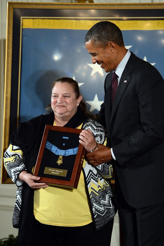 Iris Negron accepts the Medal of Honor on behalf of her late father, Army Sgt. Juan E. Negron, from President Barack Obama during a ceremony at the White House, March 18, 2014. Negron distinguished himself by acts of gallantry and intrepidity above and beyond the call of duty while assigned to the 3rd Infantry Division's Company L, 65th Infantry Regiment, during combat operations against an armed enemy in Kalma-Eri, Korea, April 28, 1951.