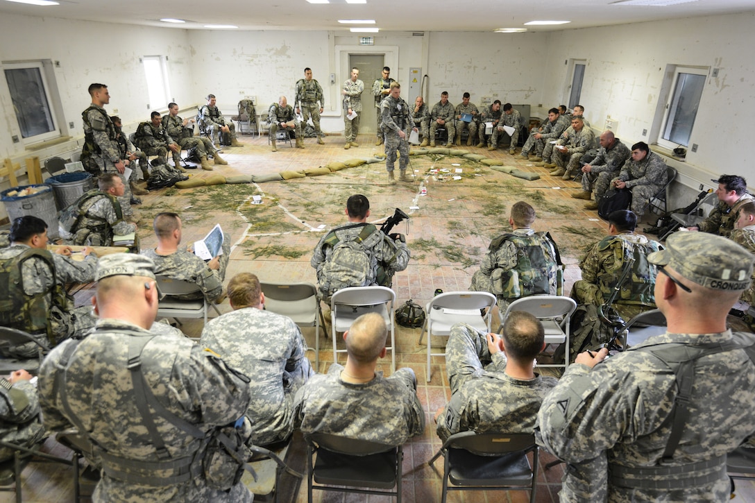 U.S. soldiers and paratroopers conduct a pre-mission brief for an air assault mission on 7th Army Joint Multinational Training Command's Hohenfels Training Area, Germany, March 19, 2014. The soldiers are assigned to 12th Combat Aviation Brigade, and the paratroopers are assigned to 1st Squadron, 91st Cavalry Regiment, 173rd Infantry Brigade Combat Team.