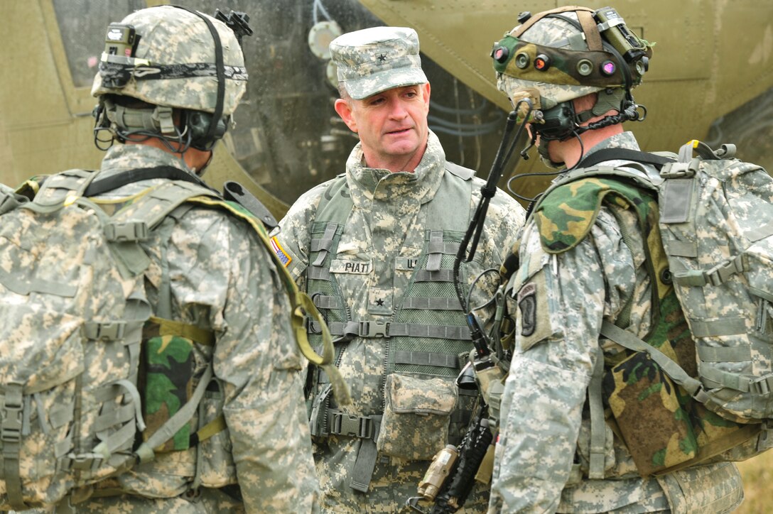 U.S. Army Brig. Gen. Walter E. Piatt, center, commander of Joint Multinational Training Command, talks to U.S. Army Capt. Colin Bair, right, and U.S. Army 1st Sgt. Christopher Valverde, left, as the paratroopers get ready to conduct an air assault mission at the 7th Army Joint Multinational Training Command's Hohenfels Training Area, Germany, March 19, 2014. Bair and Valverde are assigned to B Troop, 1st Squadron, 91st Cavalry Regiment, 173rd Infantry Brigade Combat Team.