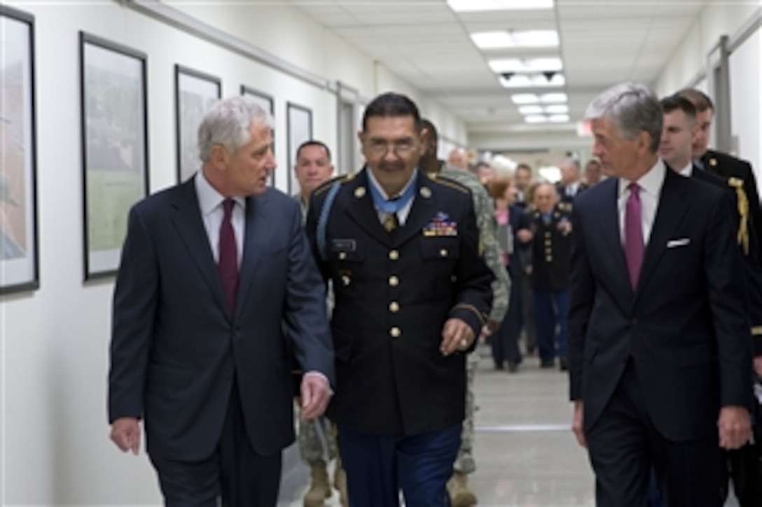 Defense Secretary Chuck Hagel, left, and Army Secretary John M. McHugh walk with Army Sgt. Santiago J. Erevia to a ceremony to induct 24 Medal of Honor recipients into the Hall of Heroes at the Pentagon, March 19, 2014. The 24 recipients fought in the Vietnam War, the Korean War and World War II.