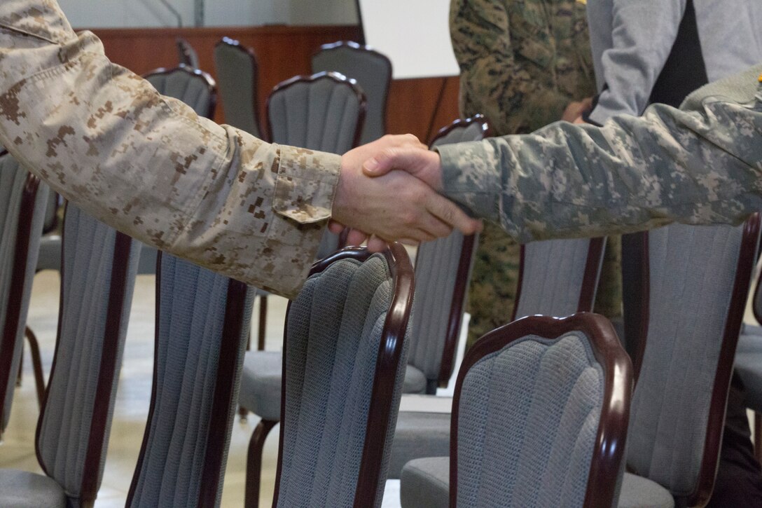 MIHAIL KOGALNICEANU, Romania - U.S. service members shake hands at the end of the Ash Wednesday service at Mihail Kogalniceanu Air Base, Mihail Kogalniceanu, Romania, March 5, 2014. Black Sea Rotational Force 14 is a contingent of Marines and sailors in the Black Sea, Balkans and Caucasus regions that work with partner nations and maintains proven partnerships while building military capacity, promoting regional stability, and providing the capability for rapid crisis response throughout Eastern Europe as directed by U.S. Marine Corps Forces Europe and Africa, and U.S. European Command. (U.S. Marine Corps photo by Lance Cpl. Samantha A. Barajas, Combat Camera, 2nd Marine Division/Released)