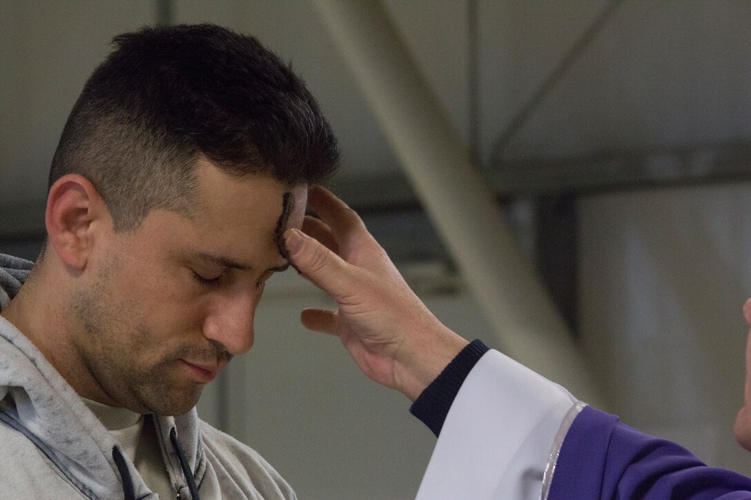 MIHAIL KOGALNICEANU, Romania - Romanian Catholic priest Balint Petre places ashes on the forehead of an attendee during the Ash Wednesday service at Mihail Kogalniceanu Air Base, Mihail Kogalniceanu, Romania, March 5, 2014. The ashes are a traditional sign of mourning and repentance. Black Sea Rotational Force-14 is a contingent of Marines and sailors in the Black Sea, Balkans and Caucasus regions that work with partner nations and maintains proven partnerships while building military capacity, promoting regional stability, and providing the capability for rapid crisis response throughout Eastern Europe as directed by U.S. Marine Corps Forces Europe and Africa, and U.S. European Command. (U.S. Marine Corps photo by Lance Cpl. Samantha A. Barajas, Combat Camera, 2nd Marine Division/ Released)