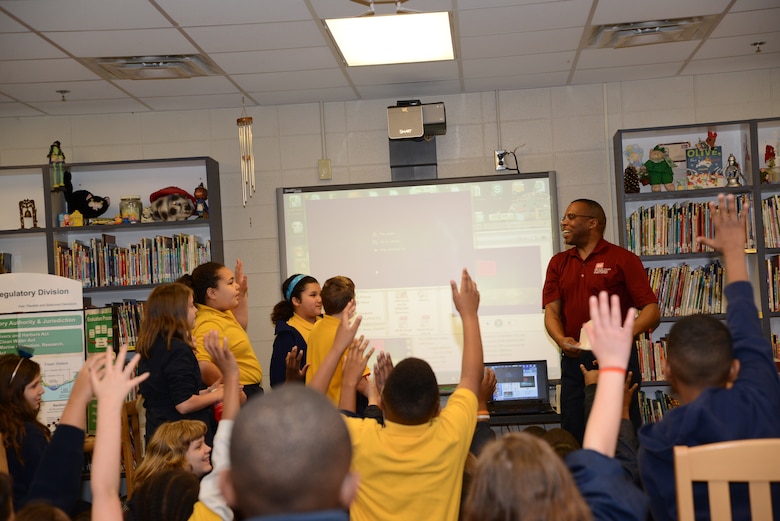 Engineer, James Hathorn looks on as students enthusiastically  answers problem solving guestions