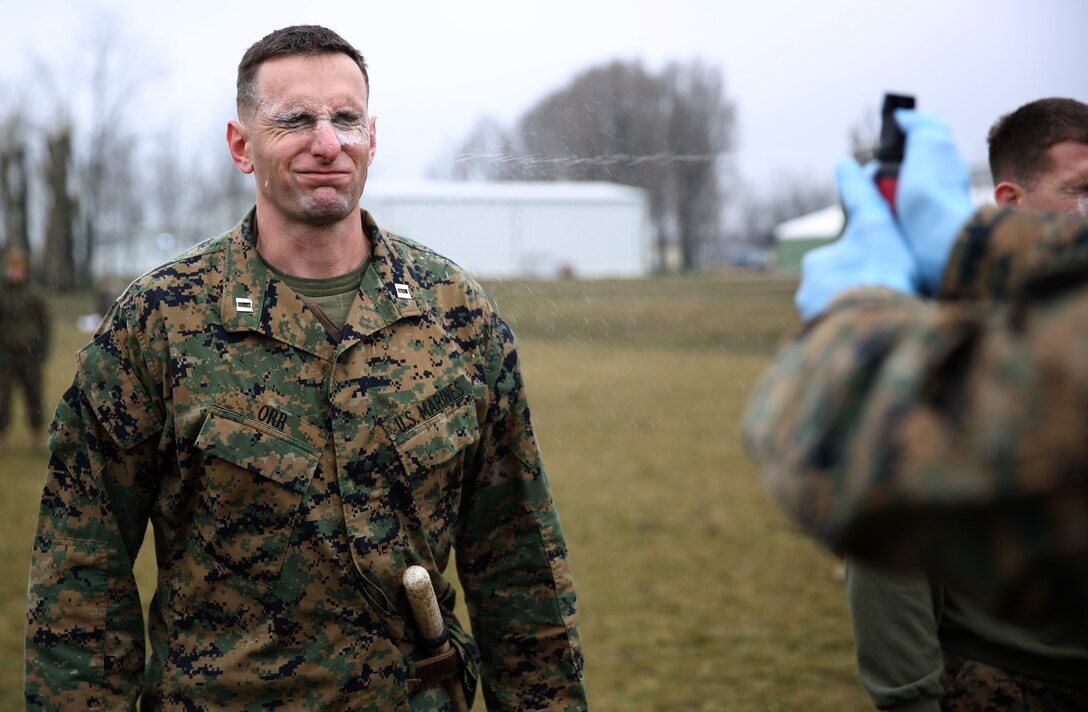 MIHAIL KOGALNICEANU, Romania - Captain Christopher Orr, commanding officer of Weapons Company, 3rd Battalion, 8th Marine Regiment, 2nd Marine Division and part of Black Sea Rotational Force 14, gets exposed to oleoresin capsicum spray during OC-contamination training on Mihail Kogalniceanu Air Base, Romania, March 5, 2014. Weapons Co. went through a mechanical arm-control holds course after being exposed to the OC spray, which helps the Marines familiarize themselves with the discomfort of being sprayed. Black Sea Rotational Force 14 is a contingent of Marines to maintain positive relations with partner nations, regional stability and increase interoperability while providing the capability for rapid crisis response, as directed by U.S. European Command, in the Black Sea, Balkan and Caucus regions of Eastern Europe. 