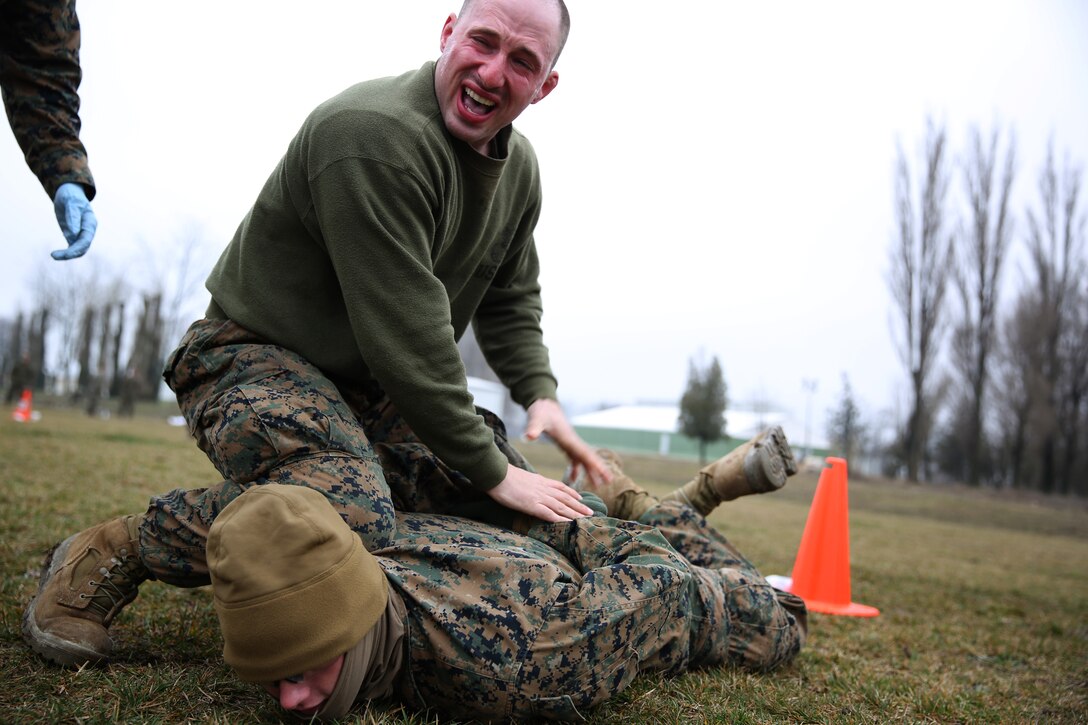 MIHAIL KOGALNICEANU, Romania - Lance Cpl. Jarod Parker, a machine gunner with Weapons Company, 3rd Battalion, 8th Marine Regiment, 2nd Marine Division and part of Black Sea Rotational Force 14, runs through a mechanical arm-control holds course after being exposed to oleoresin capsicum spray  on Mihail Kogalniceanu Air Base, Romania, March 5, 2014. The Marines were directly exposed to the OC spray, then instructed to complete a course with different stations which required them to execute different take down techniques on a simulated enemy combatant. Black Sea Rotational Force 14 is a contingent of Marines to maintain positive relations with partner nations, regional stability and increase interoperability while providing the capability for rapid crisis response, as directed by U.S. European Command, in the Black Sea, Balkan and Caucus regions of Eastern Europe. 