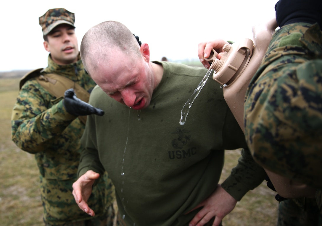 MIHAIL KOGALNICEANU, Romania - Lance Cpl. Jarod Parker, a machine gunner with Weapons Company, 3rd Battalion, 8th Marine Regiment, 2nd Marine Division and part of Black Sea Rotational Force 14, gets his eyes and face treated with water after completing a mechanical arm control holds course and being exposed to oleoresin capsicum spray  on Mihail Kogalniceanu Air Base, Romania, March 5, 2014. After completing the course, Marines are given water to mitigate the burning sensation of the spray as much as possible. Black Sea Rotational Force 14 is a contingent of Marines to maintain positive relations with partner nations, regional stability and increase interoperability while providing the capability for rapid crisis response, as directed by U.S. European Command, in the Black Sea, Balkan and Caucus regions of Eastern Europe. 