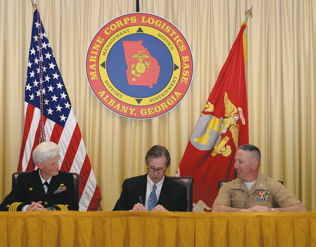 John Goldman (center) director, Carl Vinson VA Medical Center, Dublin, Ga., signs a Master Sharing Agreement Friday that allows veterans to soon receive health care services aboard Marine Corps Logistics Base Albany, Ga., as Capt. Gayle Shaffer, commanding officer Naval Hospital Jacksonville, Fla., (left) and Col. Don Davis (right) commanding officer, MCLB Albany look on.