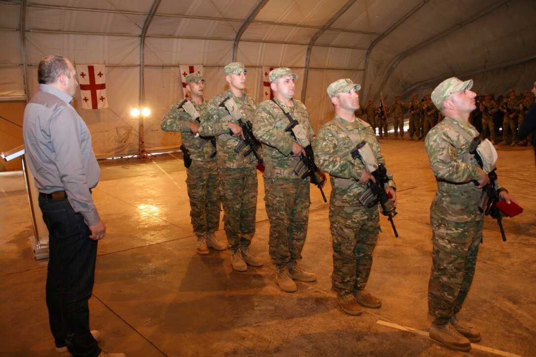 Georgian soldiers with 31st Light Infantry Battalion prepare to march off after being presented medals by Georgian President Giorgi Margvelashvili, left, during his visit to Camp Leatherneck, Helmand province, Afghanistan, March 15, 2014. During President Margvelashvili's visit, he presented numerous awards to both Georgian soldiers and U.S. Marines to show his appreciation for the outstanding work they have accomplished together.