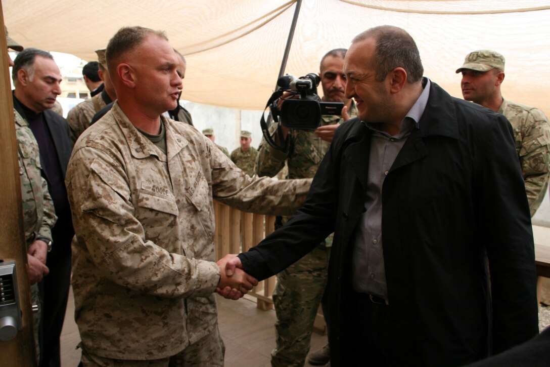 Major Ronnie L. Goode II, left, officer in charge, Georgian Liaison Team 11, shakes Georgian President Giorgi Margvelashvili's hand after presenting him with one of the 31st Light Infantry Battalion's unit patches during the president's visit to Camp Leatherneck, Helmand province, Afghanistan, March 15, 2014. This was the first time President Margvelashvili has visited his troops in Afghanistan since taking office during November 2013.