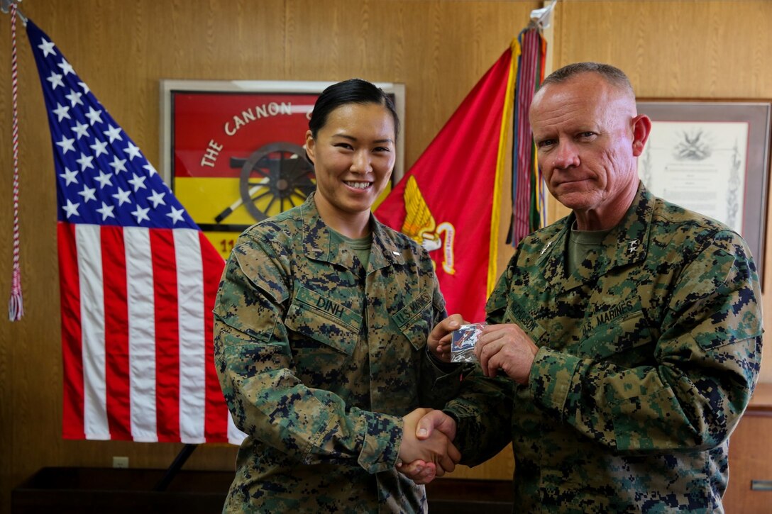 Major Gen. Lawrence Nicholson, commanding general of 1st Marine Division, congratulates 1st Lt. Thuymi Dinh, communications officer, 1st Battalion, 11th Marine Regiment on earning the Camp Pendleton female athlete of the year award at Marine Corps Base Camp Pendleton, Calif., Feb. 10, 2014. Dinh, a native of Anaheim, Calif., has participated in numerous triathlons and says she hopes to one day complete an ironman triathlon. Dinh also was a runner up in the Marine Corps female athlete of the year award. She will deploy to Afghanistan in support of Operation Enduring Freedom later this year.