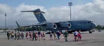 A group of Girl Scouts, Airmen and parent volunteers head toward a C-17 Globemaster III static display on the flightline at Joint Base Pearl Harbor-Hickam, Hawaii, March 17, 2014. The scouts and their leaders participated in a “pilot for-a-day” style career day hosted by the 15th Operations Group to earn the Air Force Pride Badge. (U.S. Air Force photo/Tech. Sgt. Terri Paden)