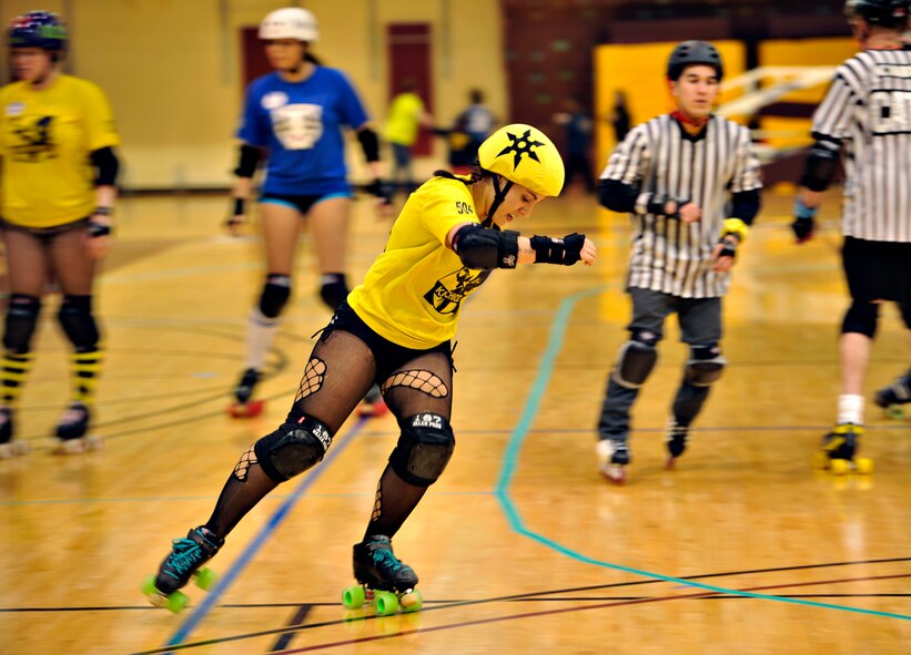 Risky Bizness, also known as Senior Airman Lindsey Rath, 36th Fighter Squadron operations intelligence analyst, turns a corner during a roller derby bout at U.S. Army Garrison Humphreys, Republic of Korea, March 8, 2014. Rath is one of several active duty military members that make up the KimChicks roller derby team. (U.S. Air Force photo/Senior Airman Siuta B. Ika)