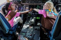 Brownie Girl Scouts Tatyana Stewart, (left) and Emily Wilson, (right), simulate flying a C-17 Globemaster III while touring the inside of the aircraft as part of a Girl Scout tour on Joint Base Pearl Harbor-Hickam, Hawaii, March 17, 2014. The girls were on base to participate in a “pilot for-a-day” style career day hosted by the 15th Operations Group, in order to earn the Air Force Pride Badge. (U.S. Air Force photo/Tech. Sgt. Terri Paden)