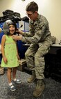 Airman 1st Class Justin Duncan, 15th Operations Support Squadron Aircrew Flight Equipment technician, helps Victoria Doyle don a helmet with night vision goggles as part of a Girl Scout tour on Joint Base Pearl Harbor-Hickam, Hawaii, March 17, 2014. In addition to a C-17 Globemaster III static display, the girls were taught how to use aircrew flight equipment such as parachutes and night vision goggles, how to load and secure cargo and how to build a temporary hospital for aeromedical evacuations. (U.S. Air Force photo/Tech. Sgt. Terri Paden)