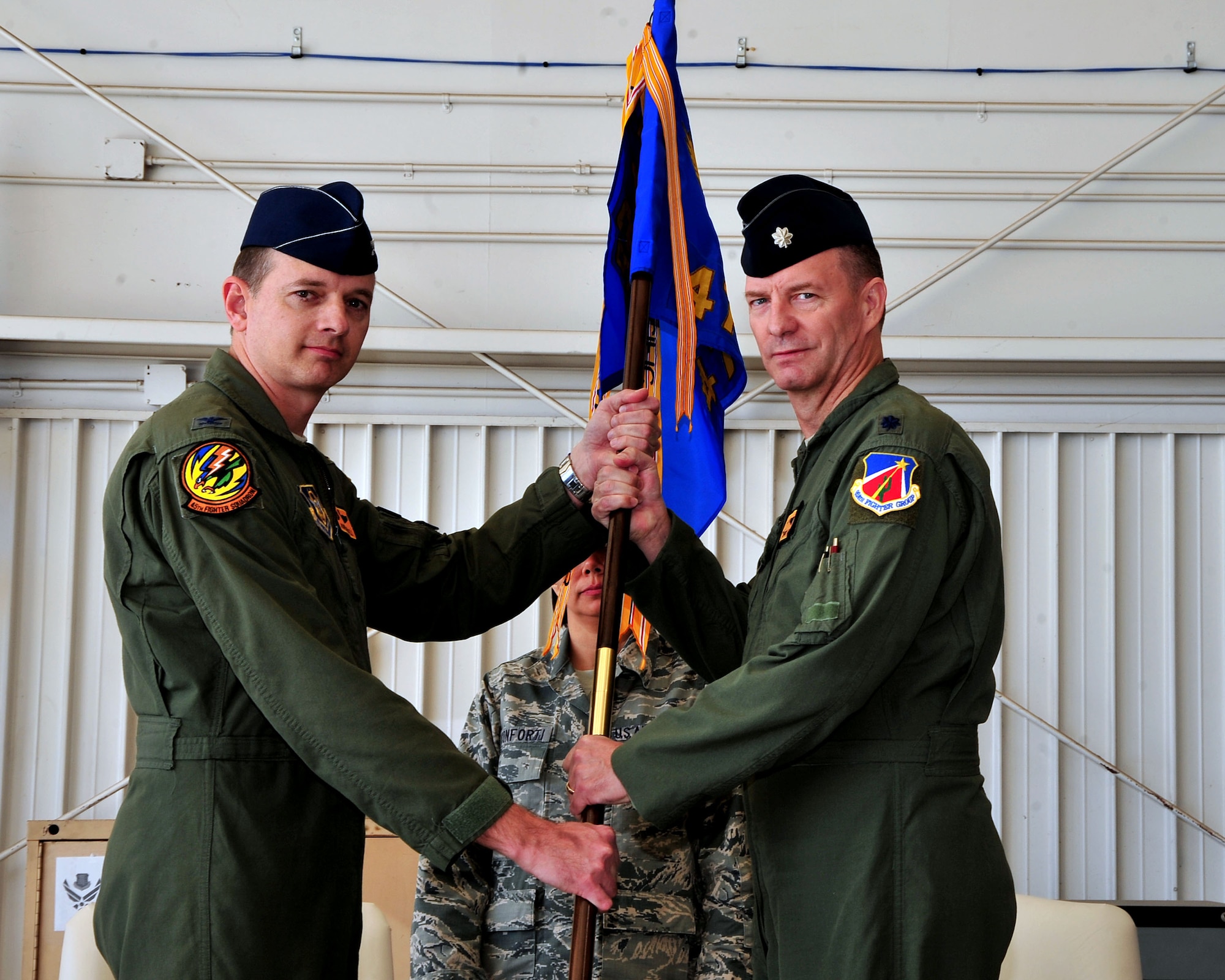 Col John Russell, 924 Fighter Group commander, hands the 47th Fighter Squadron guide on to Lt Col Terry McClain as he assumes command of the 47th FS. The 924th Fighter Group held a unit inactivation and assumption of command ceremony at Davis-Monthan Air Force Base, Ariz. March 8.
