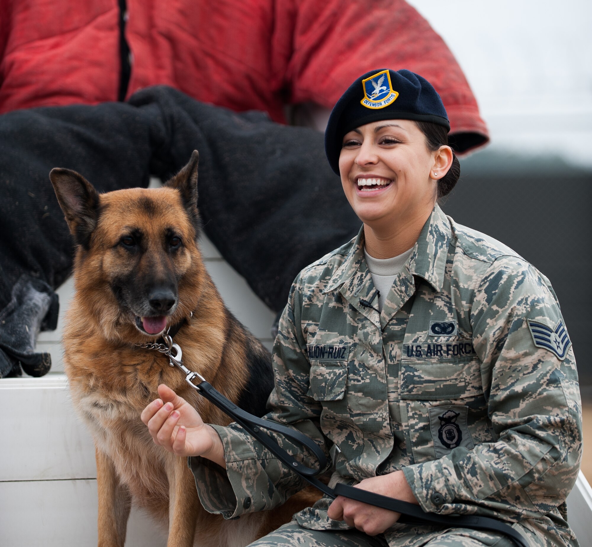 Staff Sgt. Monica Bizallion, 8th Security Forces Squadron military working dog handler, poses for a photo with Stella, 8th SFS military working dog, at Kunsan Air Base, Republic of Korea, Mar. 13, 2014.  Bizallion and Stella defend the base by detecting, deterring and neutralizing the threats that may appear. (U.S. Air Force photo by Staff Sgt. Clayton Lenhardt/Released)