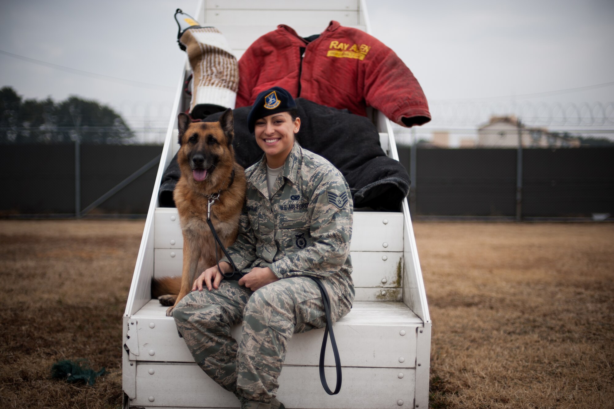 Staff Sgt. Monica Bizallion, 8th Security Forces Squadron military working dog handler, poses for a photo with Stella, 8th SFS military working dog, at Kunsan Air Base, Republic of Korea, Mar. 13, 2014.  Bizallion and Stella defend the base by detecting, deterring and neutralizing the threats that may appear. (U.S. Air Force photo by Staff Sgt. Clayton Lenhardt/Released)