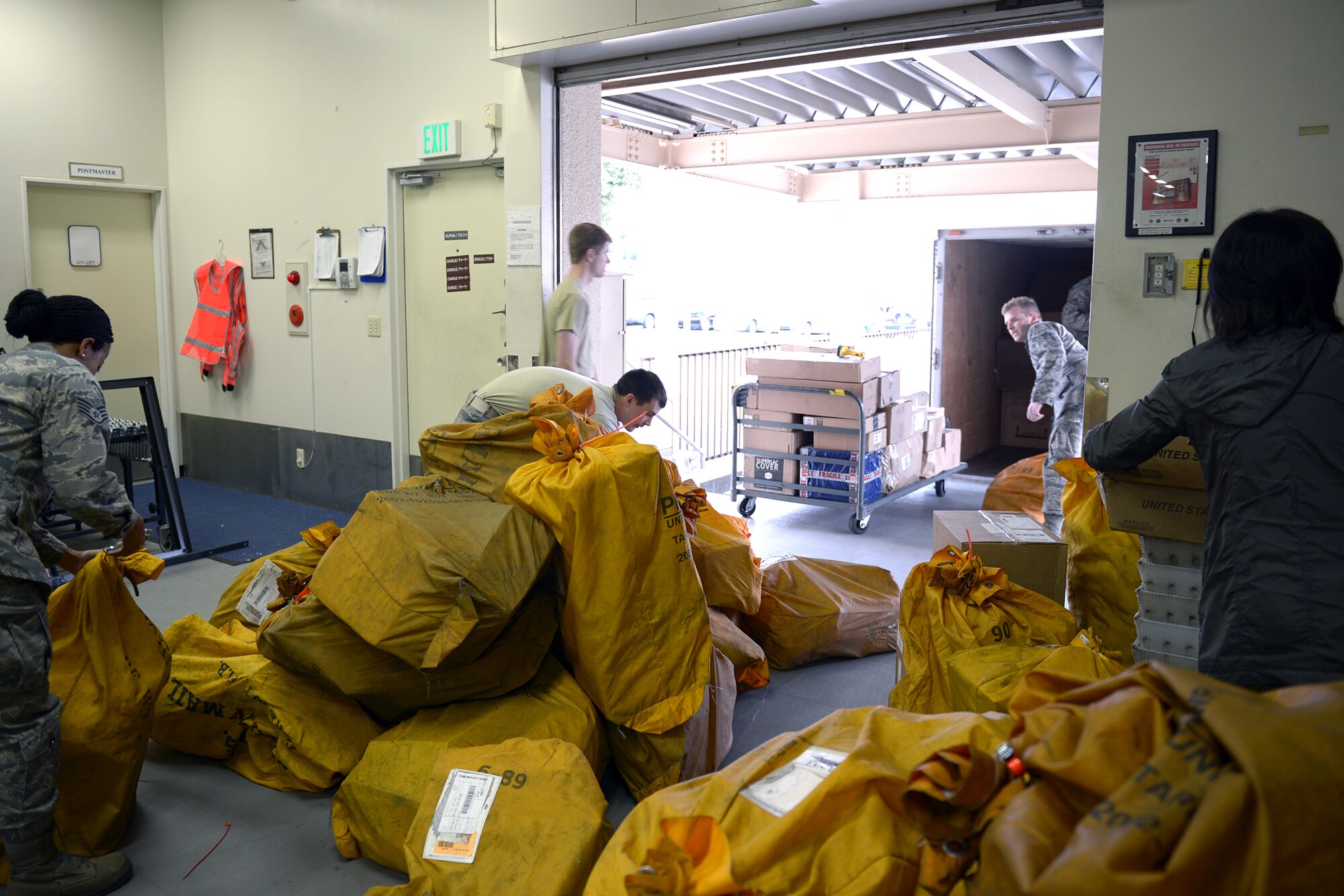 Airmen from the 374th Communications Squadron unload a delivery truck at Yokota Air Base, Japan, March 19, 2014. The Yokota post office processes an average of 1.5 million pounds of mail per year. (U.S. Air Force photo by Airman 1st Class David Danford/Released) 