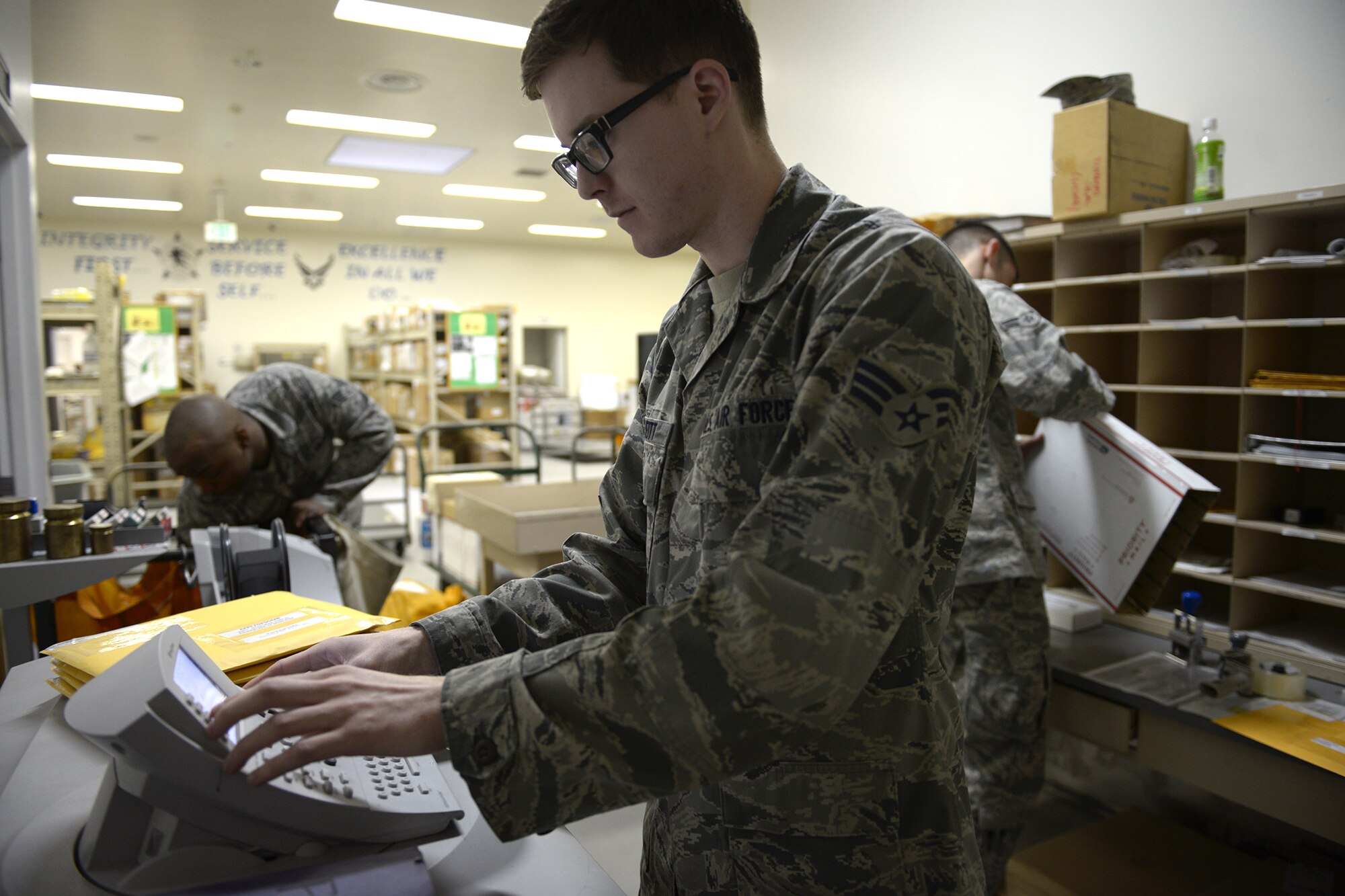 Senior Airman Justin Dueitt, 374th Communications Squadron postal specialist, processes mail using the Pitney Bowes machine at Yokota Air Base, Japan, March 19, 2014. The Pitney Bowes machine is used for all of the Wing’s official mail. (U.S. Air Force photo by Airman 1st Class David Danford/Released)