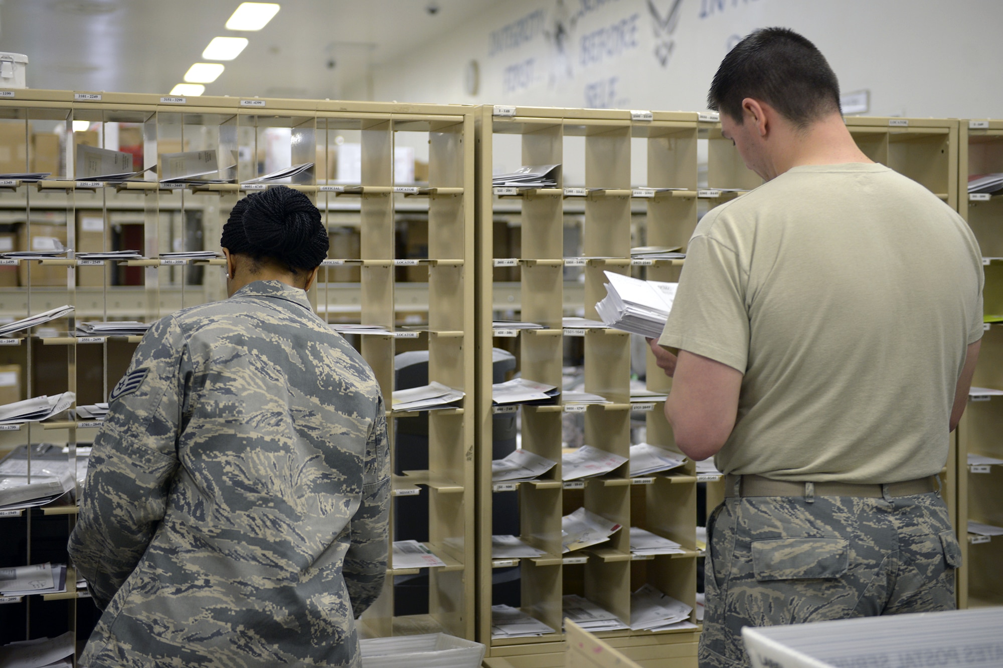 Staff Sgt. Monica Williams and Staff Sgt. Michael Proud, 374th Communications Squadron postal specialists, sort mail at Yokota Air Base, Japan, March 19, 2014. Yokota’s post office serves as a line of communication between Airmen and their families in the U.S. (U.S. Air Force photo by Airman 1st Class David Danford/Released)
