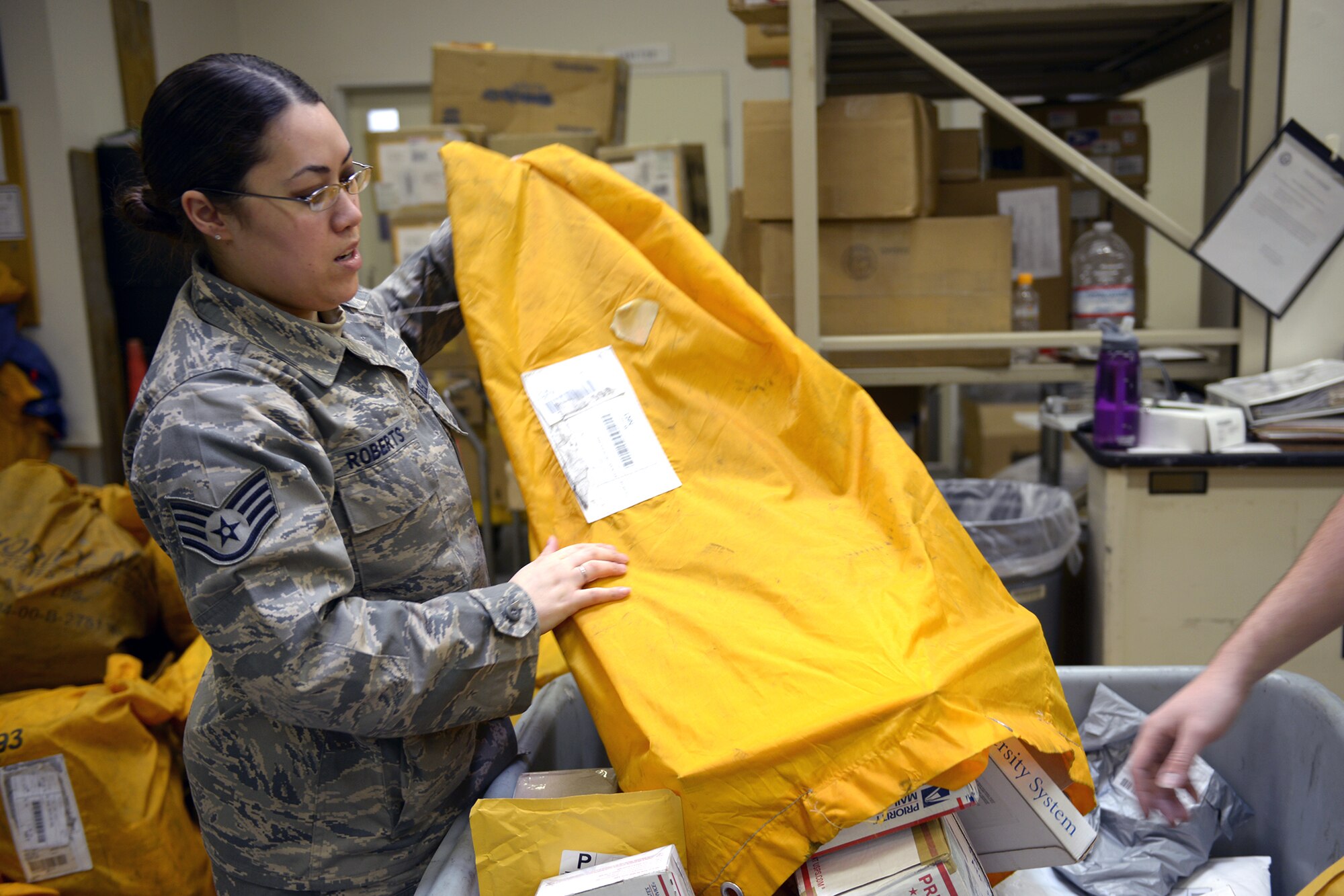 Staff Sgt. Leah Roberts, 374th Communications Squadron postal specialist, empties packages into a mail cart at Yokota Air Base, Japan, March 19, 2014. The Yokota post office provides full service, processing both incoming and outgoing mail, in addition to working with money orders and postal stamps. (U.S. Air Force photo by Airman 1st Class David Danford/Released)