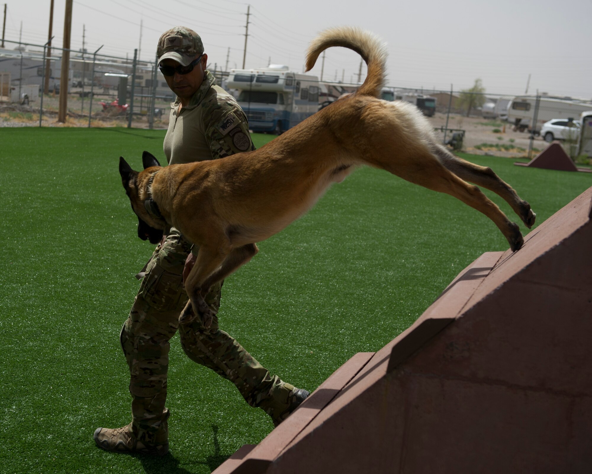 Chris Lopez, a Border Patrol agent, and patrol K-9 Joe run obstacles as a part of obedience training outside the Military Working Dog facility at Holloman Air Force Base, N.M., March 19. Holloman’s 49th Security Forces Squadron Military Working Dog Unit hosted quarterly training with multiple law enforcement agencies from the surrounding areas including Border Patrol, New Mexico State University and Fort Bliss. The day consists of emergency veterinary procedure training, comparing tactics of entering a building and capturing a decoy, obedience training, and bomb search and detection. (U.S. Air Force photo by Airman 1st Class Chase Cannon/ Released)