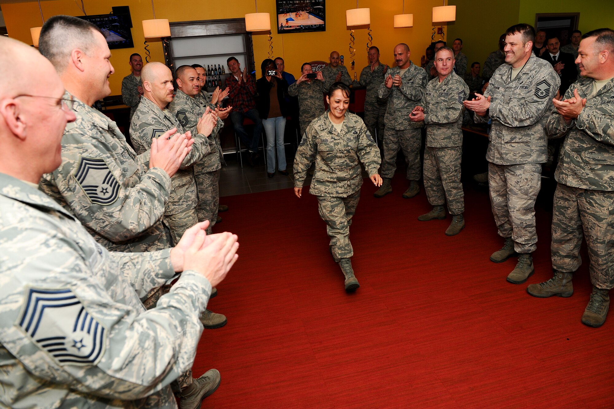 Master Sgt. Christina Duran, Air Reserve Personnel Center, walks through a gauntlet at the Team Buckley Senior Master Sergeant Release Party March 20, 2014, at Panther’s Den on Buckley Air Force Base, Colo. Duran was one of five senior master sergeant selects for Team Buckley and one of 999 selects for the Air Force. (U.S. Air Force photo by Senior Airman Phillip Houk/Released)