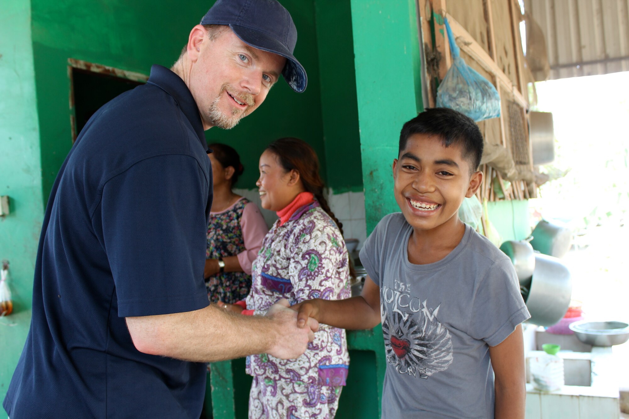 Andy Schad, U.S. Air Force civilian, reservist, and Air War College student, presents an Air War College coin to a Cambodian orphan during a visit to the New Hope for Cambodian Children orphanage, in Phnom Penh, March 14. Air War College students and faculty visited the orphanage to gain an understanding of social issues facing Cambodia. As part of the Air War College Regional and Cultural Studies curriculum, students studied the region's political, social, military, diplomatic and economic needs during their field study, March 1-14, 2014. (Courtesy Photo)