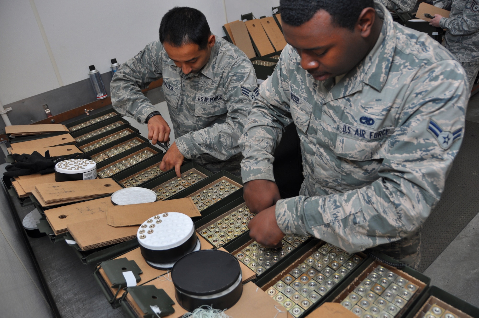 Airman 1st Class Raashawyn Bush, 60th Maintenance Squadron munitions storage crewmember, and Senior Airman Rul Malta, 60th MXS munitions inspector, install impulse cartridges into decoy flare March 11 during the units semiannual flare build. The flare are a critical defense capability for the C-5 Galaxy and C-17 Globemaster III.  (U.S. Air Force photo/Senior Airman Bryan Swink)