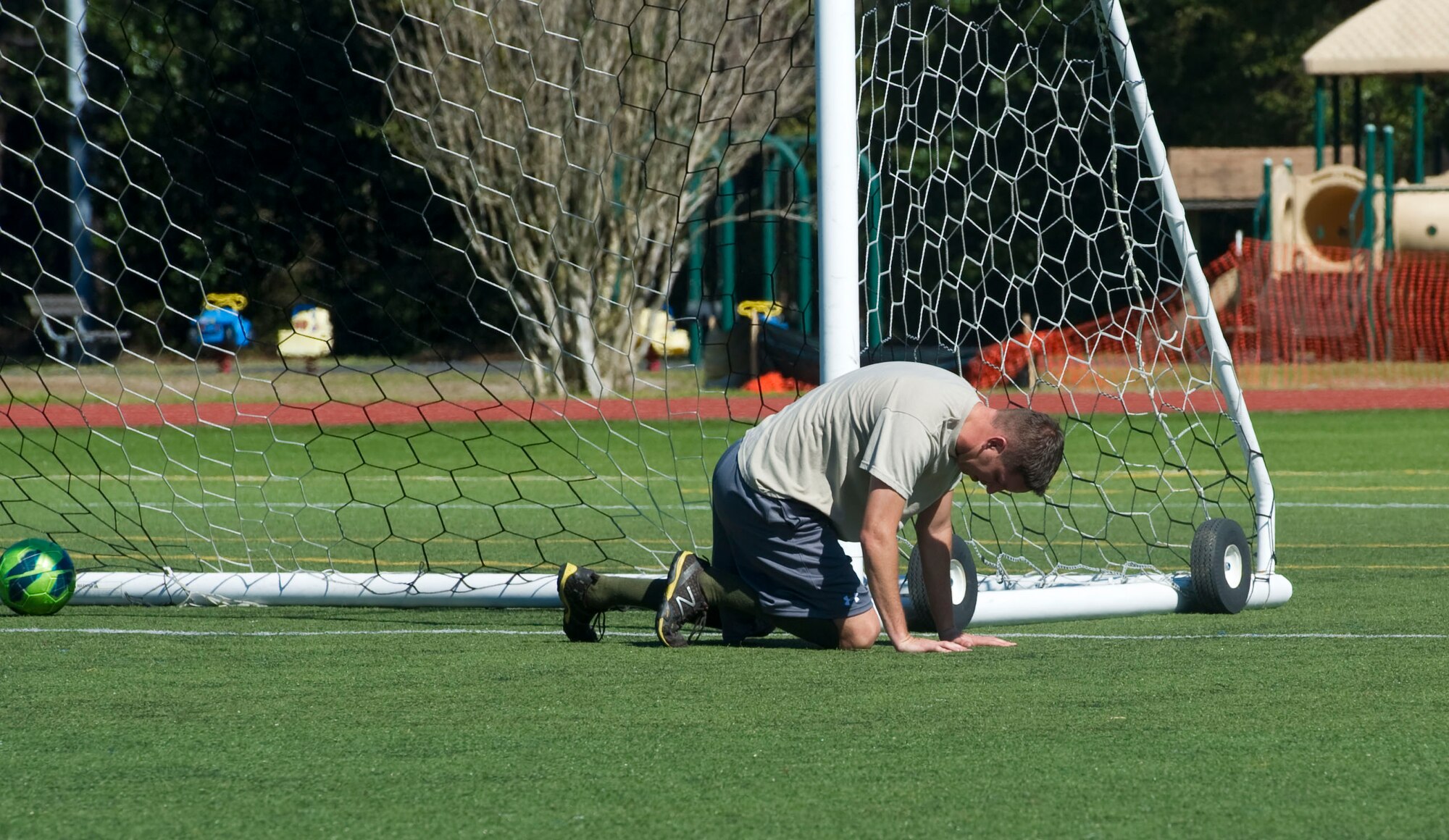 An Airman from Detachment 7, 373rd Training Squadron falls to the ground after missing a ball during a soccer match on the Adherholt Fitness Center field at Hurlburt Field, Fla., March 19, 2014. The intramural soccer season is scheduled to begin June 2, and any Department of Defense card-holder may participate. (U.S. Air Force photo/Senior Airman Naomi Griego)