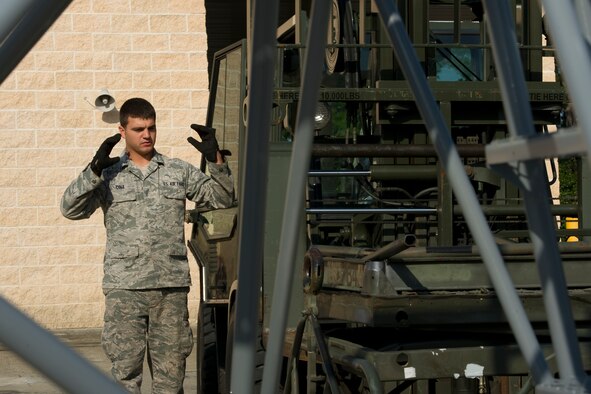 Senior Airman Thomas Cole, 1st Special Operations Logistics Readiness Squadron vehicle operator, guides a forklift on the flightline at Hurlburt Field, Fla., March 20, 2014. Cole can operate a variety of vehicles including forklifts, large buses and tractor trailers. (U.S. Air Force photo/Senior Airman Naomi Griego)