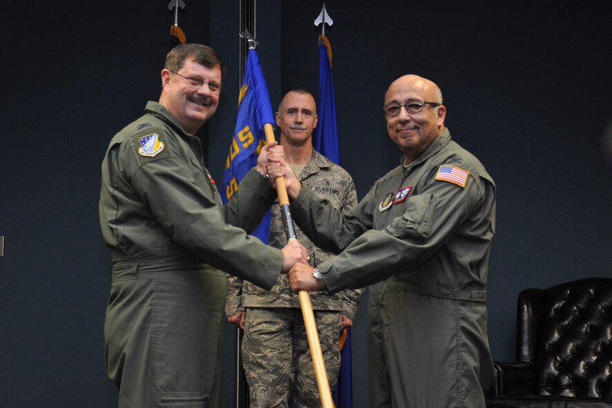 Col. Eduardo San Miguel presents the 916th Aerospace Medicine Squadron guidon to Col. Gregory Gilmour, 916th Air Refueling Wing commander, during a change of command ceremony, February 2014. San Miguel was replaced by Col. Stephen Irvin as AMDS commander. (U.S. Air Force photo by Staff Sgt. Alan Abernethy, 916th ARW/PA)
