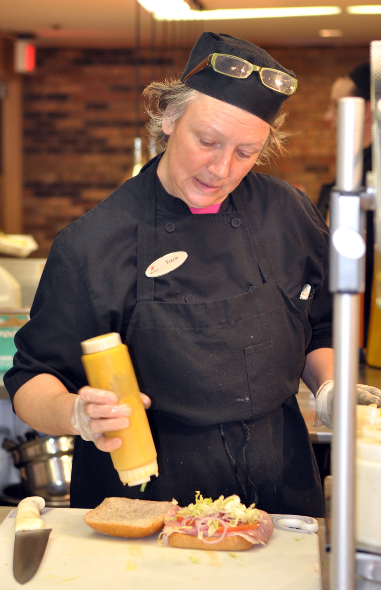 Tracie Carter prepares a sandwich for a diner in Café 3001. The café boasts new items such as low calorie wraps, chicken and tuna salad. (Air Force photo by Kimberly Woodruff)