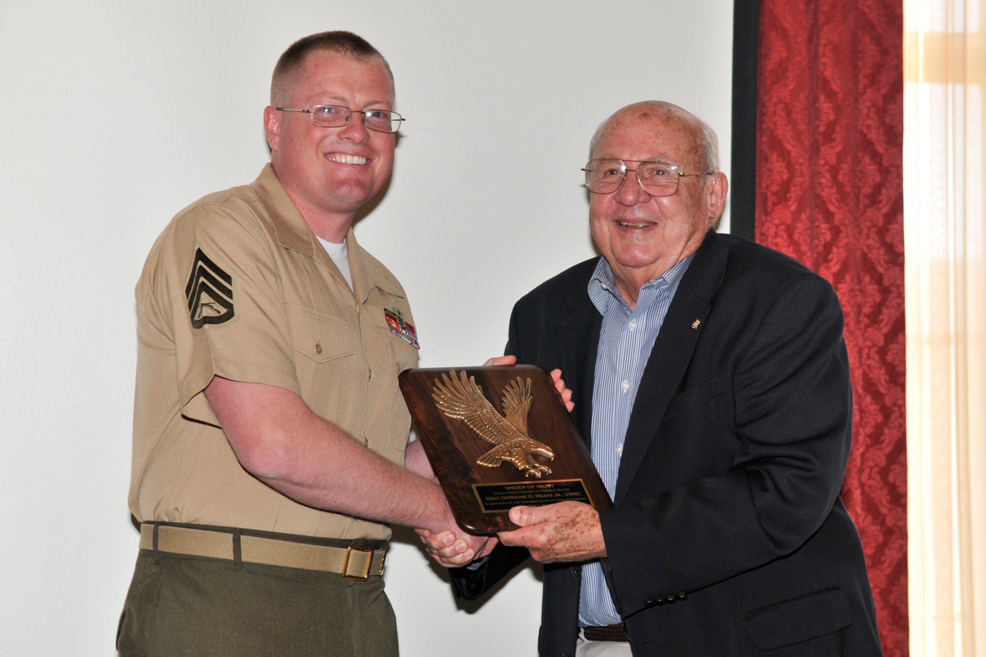 SAN ANGELO, Texas – Retired Col. Charles Powell, former 17th Training Wing Commander, presents the Order of Merit award to Marine Corps Staff Sgt. DeWayne Meats Jr., Marine Corps Detachment and Louis F. Garland DOD Fire Academy Crash Fire Rescue instructor during a Chamber of Commerce membership luncheon at the Cactus Hotel March 11. The Order of Merit award was presented to Meats in recognition of his involvement with the community here. (U.S. Air Force Photo/ Airman 1st Class Devin Boyer)