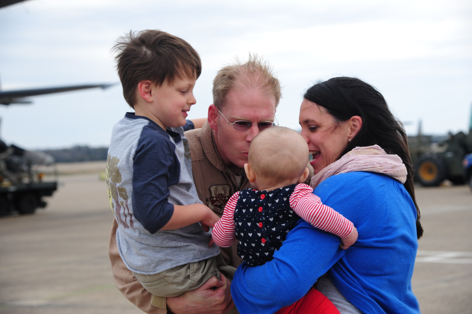 Maj. Adam Shockley, a member of the 61st Airlift Squadron, hugs his family after coming home from a deployment March 14, 2014, at Little Rock Air Force Base, Ark. Little Rock AFB is the home of combat airlift with more than 80 C-130s assigned to the installation. (U.S. Air Force photo by Senior Airman Kaylee Clark) 