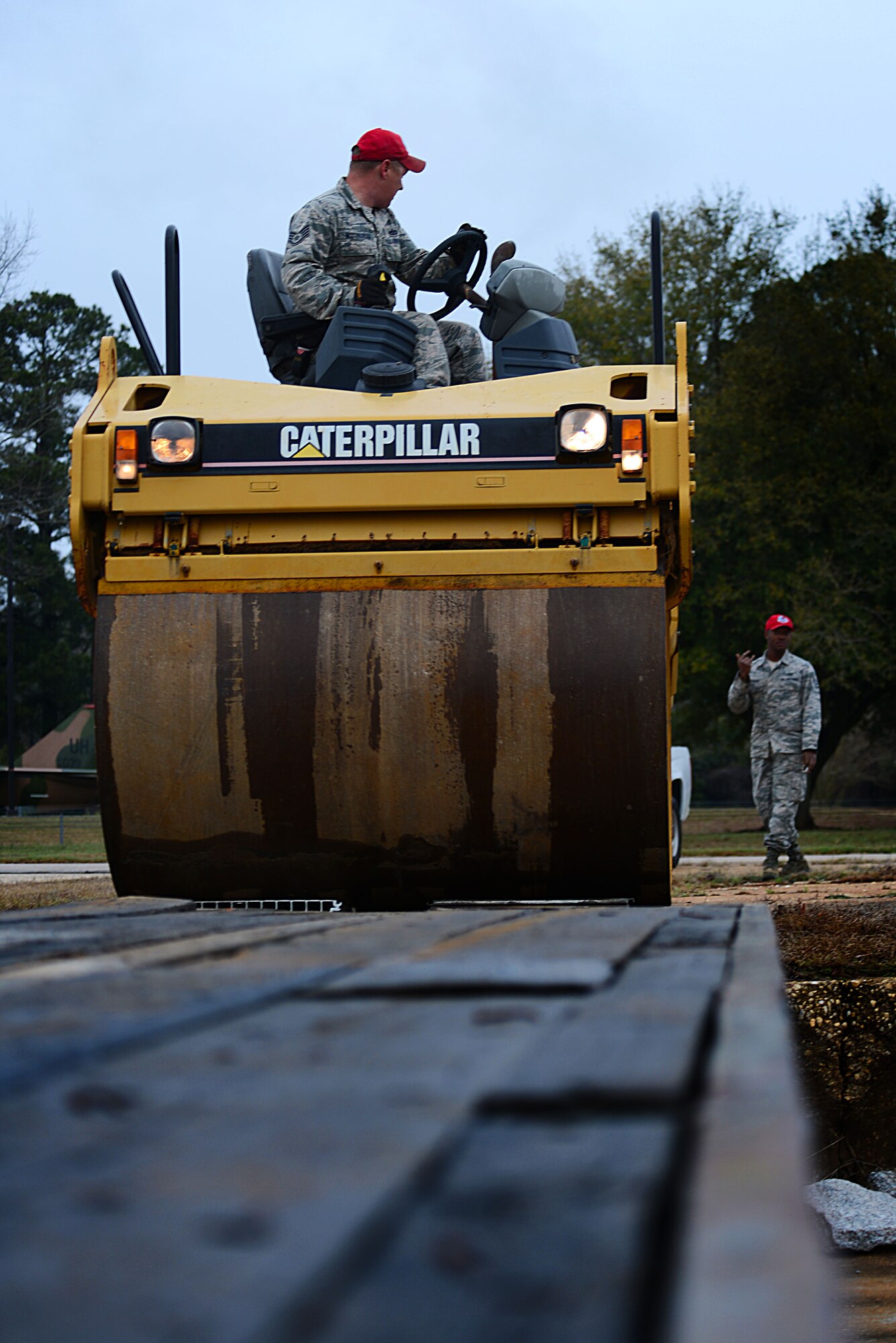 U. S. Air Force Staff Sgt. Randall McCunegould, 823rd RED HORSE pavement and equipment operator assigned to Hurlburt Field, Fla., drives steam roller off a truck bed at Shaw Air Force Base, S.C., March 18, 2014. Following two additional shipments, McCunegould and his team will have unloaded a total of 25 pieces of heavy equipment for a road paving project. (U.S. Air Force photo by Airman 1st Class Jensen Stidham/Released)
