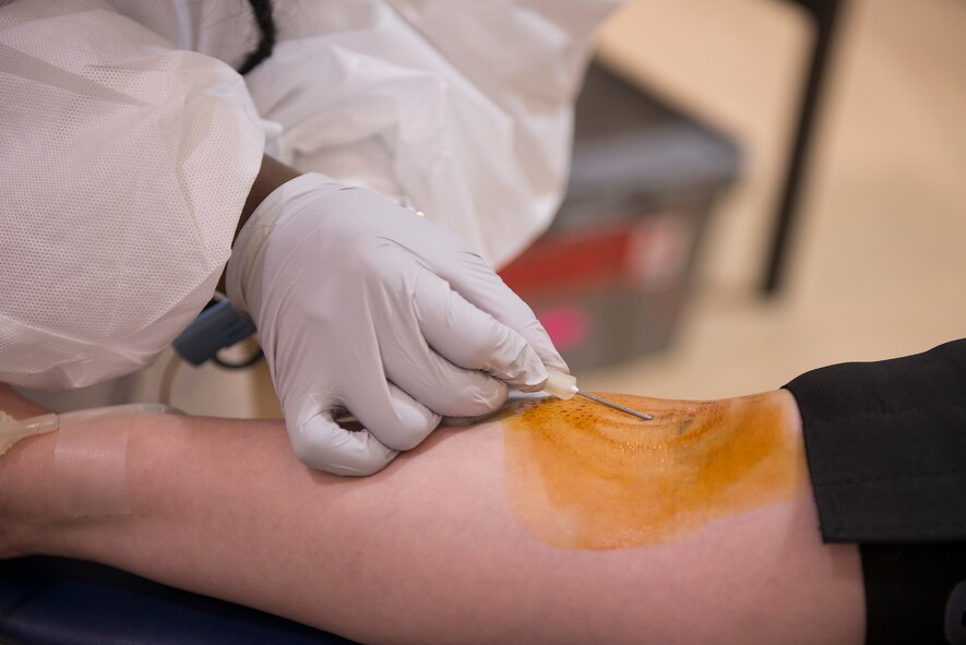 Brittany Arthur, American Red Cross collection technician, inserts a needle into the arm of U.S. Air Force Airman 1st Class Alexis Millican, 23d Wing Public Affairs photojournalist, to take a blood donation at the Freedom 1 Fitness Center at Moody Air Force Base, Ga., March 19, 2014. Due to severe, winter weather, 51 red cross blood drives were cancelled across the state of Georgia this year. (U.S. Air Force photo by Senior Airman Tiffany M. Grigg/Released) 