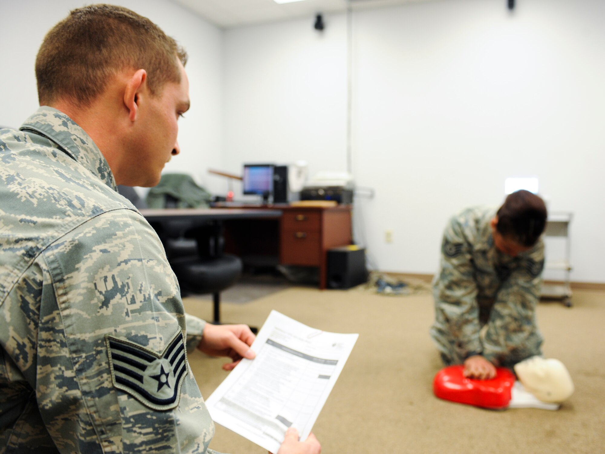 U.S. Air Force Staff Sgt. Jason Hatfield, 355th Equipment Maintenance Squadron cardiopulmonary resuscitation instructor, evaluates the CPR knowledge and performance of Tech. Sgt. Veronica Torres, 355th EMS flight training manager, at Davis-Monthan Air Force Base, Ariz., March 18, 2014. The act of CPR is to restore the partial flow of oxygenated blood to the brain and heart. (U.S. Air Force photo by Senior Airman Sivan Veazie/Released)