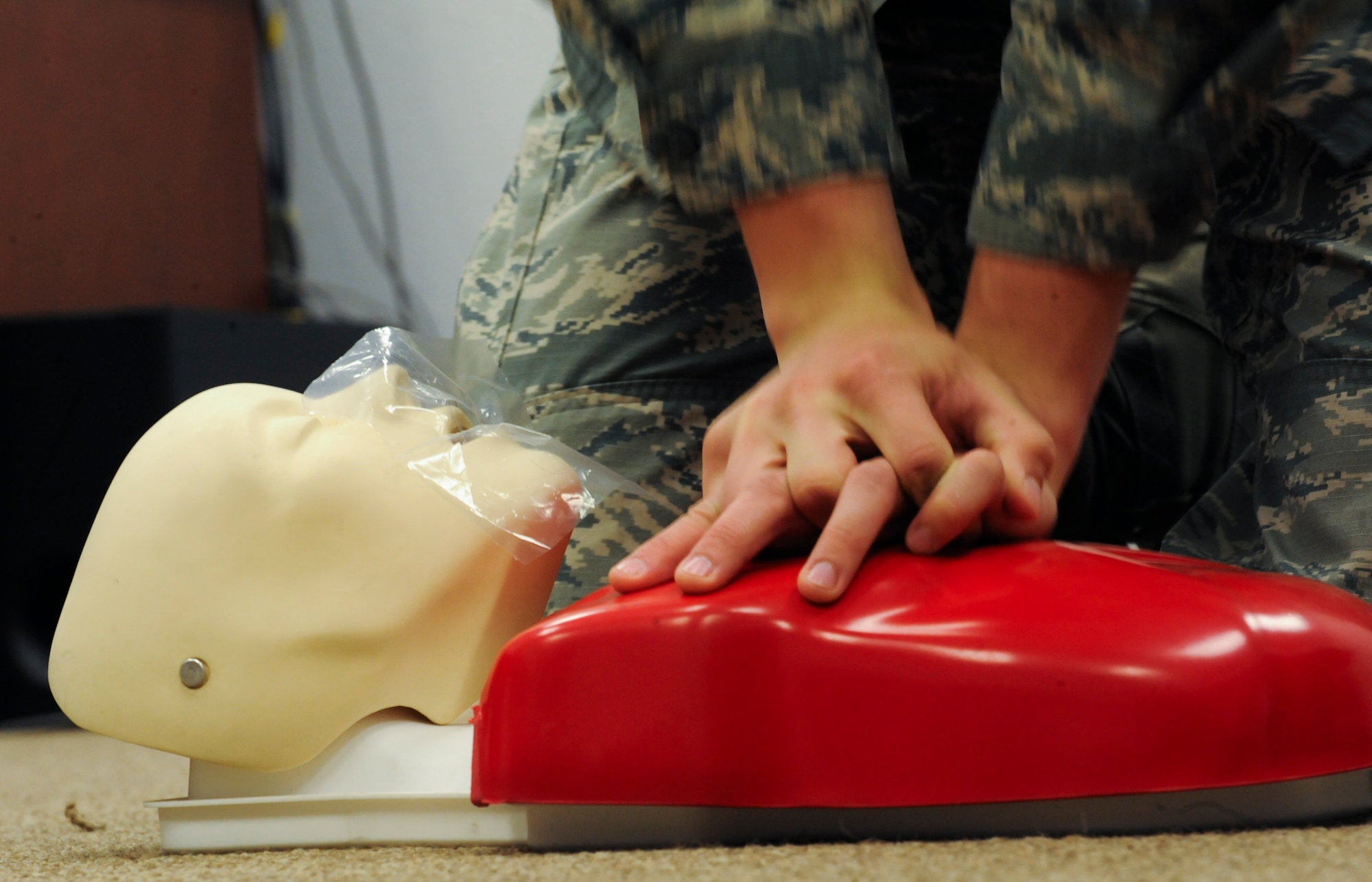 U.S. Air Force 2nd Lt. Alexander Manners, 612th Air Communication Squadron command, control, communications, computers and intelligence (C4I) infrastructure officer in charge, performs compressions on a practice dummy during a cardiopulmonary resuscitation training session at Davis-Monthan Air Force Base, Ariz., March 18, 2014. According to the International Liaison Committee on Resuscitation guidelines, CPR involves chest compressions at least two inches deep and at a rate of at least 100 compressions per minute to pump blood through the heart and to the body. (U.S. Air Force photo by Senior Airman Sivan Veazie/Released)
