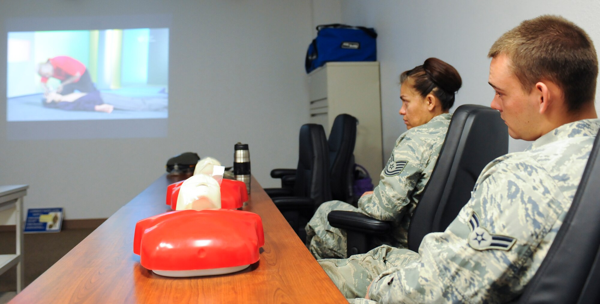 U.S. Air Force Airman 1st Class Kyle Bathory, 355th Equipment Maintenance Squadron aerospace ground equipment journeyman, and Tech. Sgt. Veronica Torres, 355th EMS flight training manager, watch a film during a cardiopulmonary resuscitation training session at Davis-Monthan Air Force Base, Ariz., March 18, 2014. CPR is an emergency procedure for manually preserving brain function until further measures to restore spontaneous blood circulation and breathing in a person who is in cardiac arrest. (U.S. Air Force photo by Senior Airman Sivan Veazie/Released)