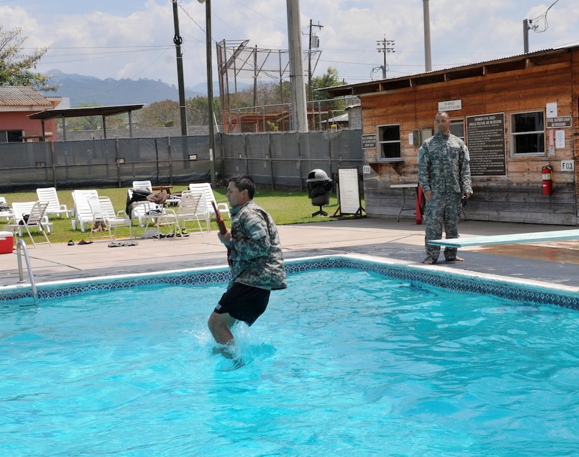 U.S.Army 1LT Sequoya Dudley oversees a service member as he begins the 15-meter swim with a M16 part of the Combat Water Survival training, conducted in the base pool in Soto Cano Air Base, Honduras; Mar. 13, 2014. (Photo by Ana Fonseca)


