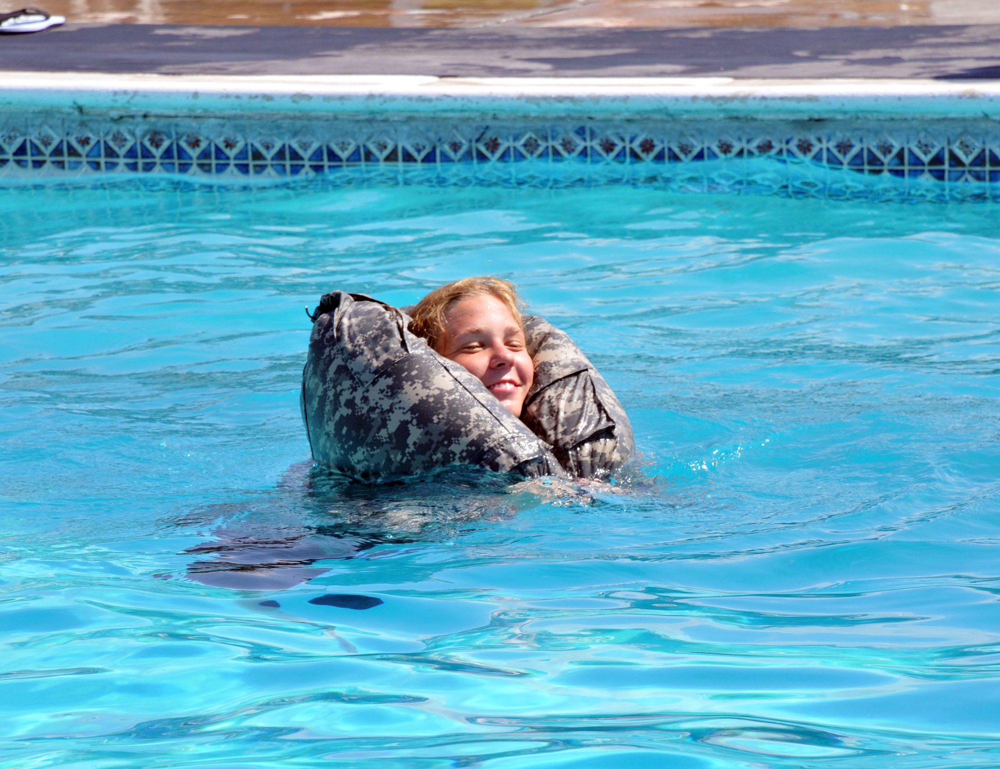 A service member successfully uses her trouser as a floating device. Joint Task Force-Bravo’s Army Forces Battalion (ARFOR) and Medical Element (MEDEL) service members conducted a Combat Water Survival training at the Soto Cano Air Base pool; Mar. 13, 2014. (Photo by Ana Fonseca)



