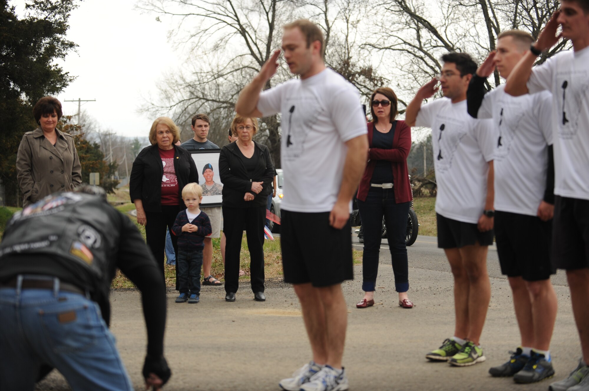 A gold-star mother watches as Arkansas Run for the Fallen runners render a salute in homage to a fellow Arkansan March 15, 2014, at Clarksville, Ark. Every mile, for 133 miles, a member of the running group read the biography card, placed it in the ground at the designated memorial site for the fallen service member and rendered a salute. (U.S. Air Force photo by Airman 1st Class Cliffton Dolezal)