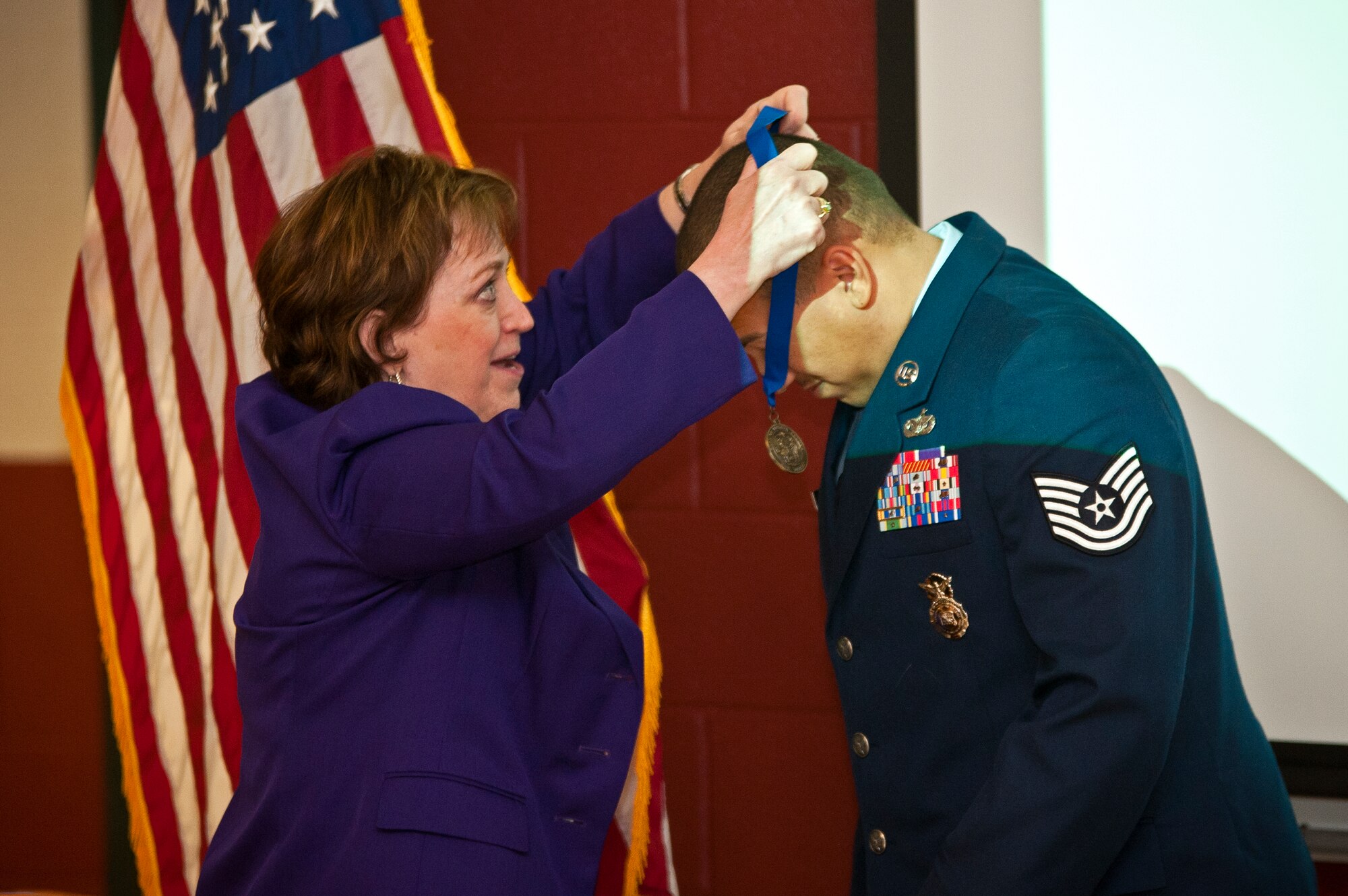 Kathleen Donovan, Bergen County executive, awards Tech. Sgt. Brian Williams, 87th Security Forces Squadron military working dog handler, with the Bergen County Military Service Medal March 14, 2014, at the second annual K-9 Veterans Day celebration at the Bergen County Law and Public Safety Institute in Mahwah, N.J. Williams was made an honorary county member for his military service and selfless actions during a 2012 mission in Southern Afghanistan where he sustained serious injuries. (U.S. Air Force photo/Staff Sgt. Scott Saldukas)